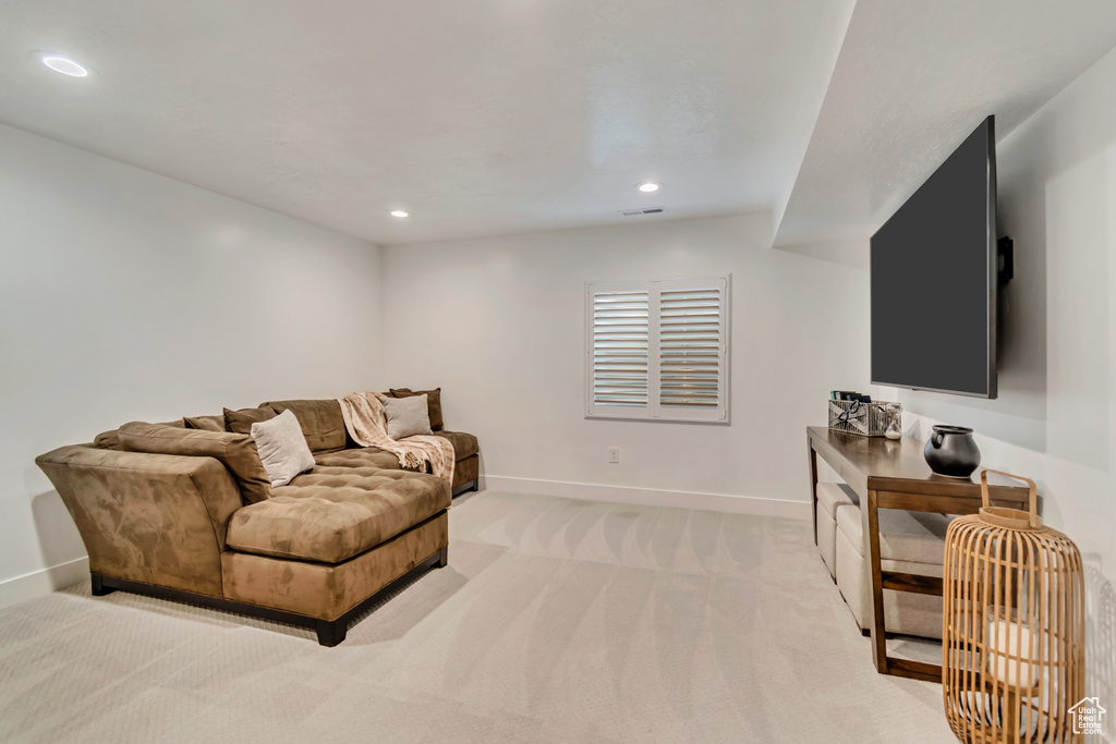 Living room featuring baseboards, light carpet, and recessed lighting