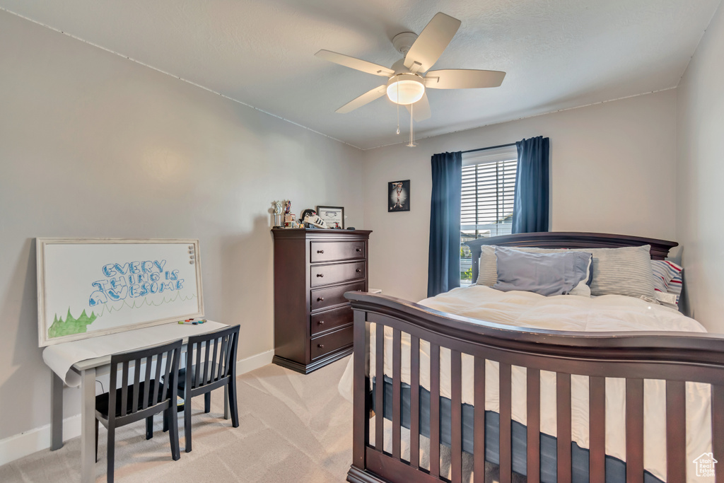 Bedroom with baseboards, light carpet, and a ceiling fan