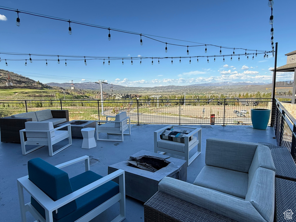 View of patio / terrace featuring an outdoor living space with a fire pit and a mountain view