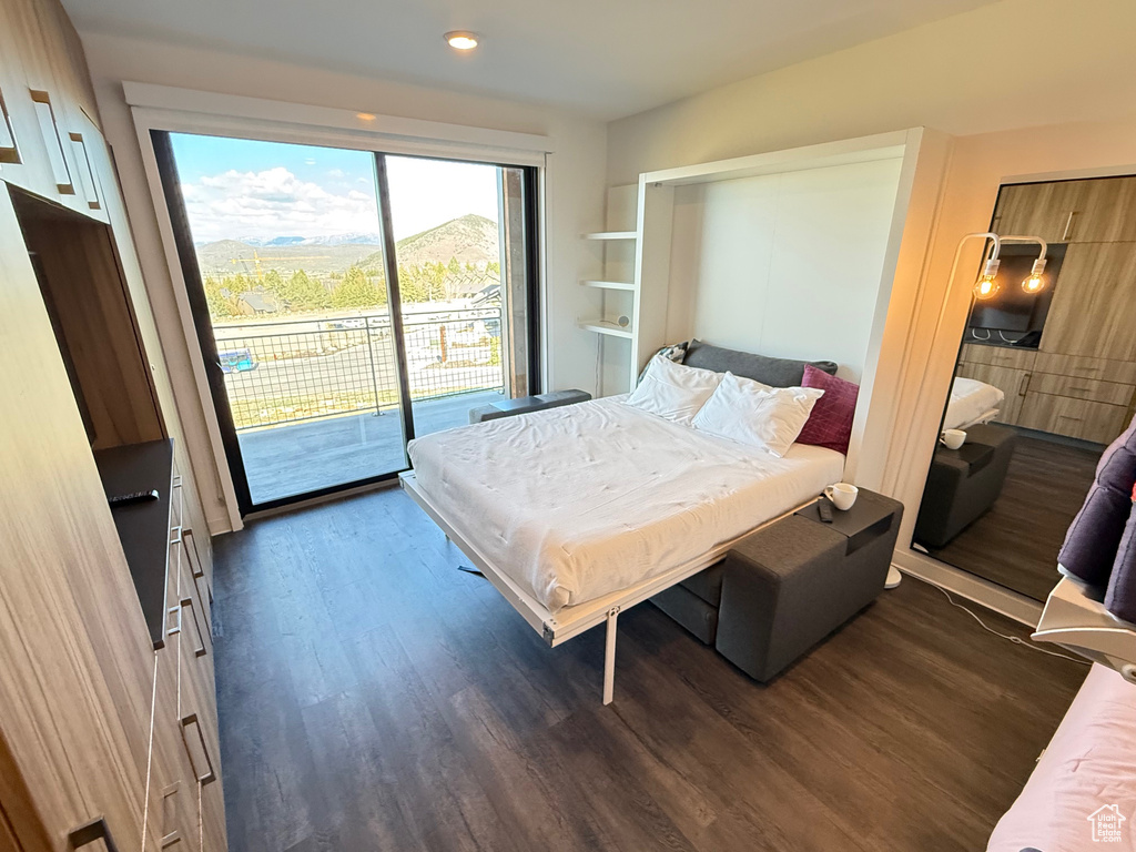 Bedroom with access to exterior, dark wood finished floors, and recessed lighting