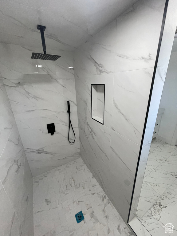 Bathroom with marble finish flooring and a marble finish shower