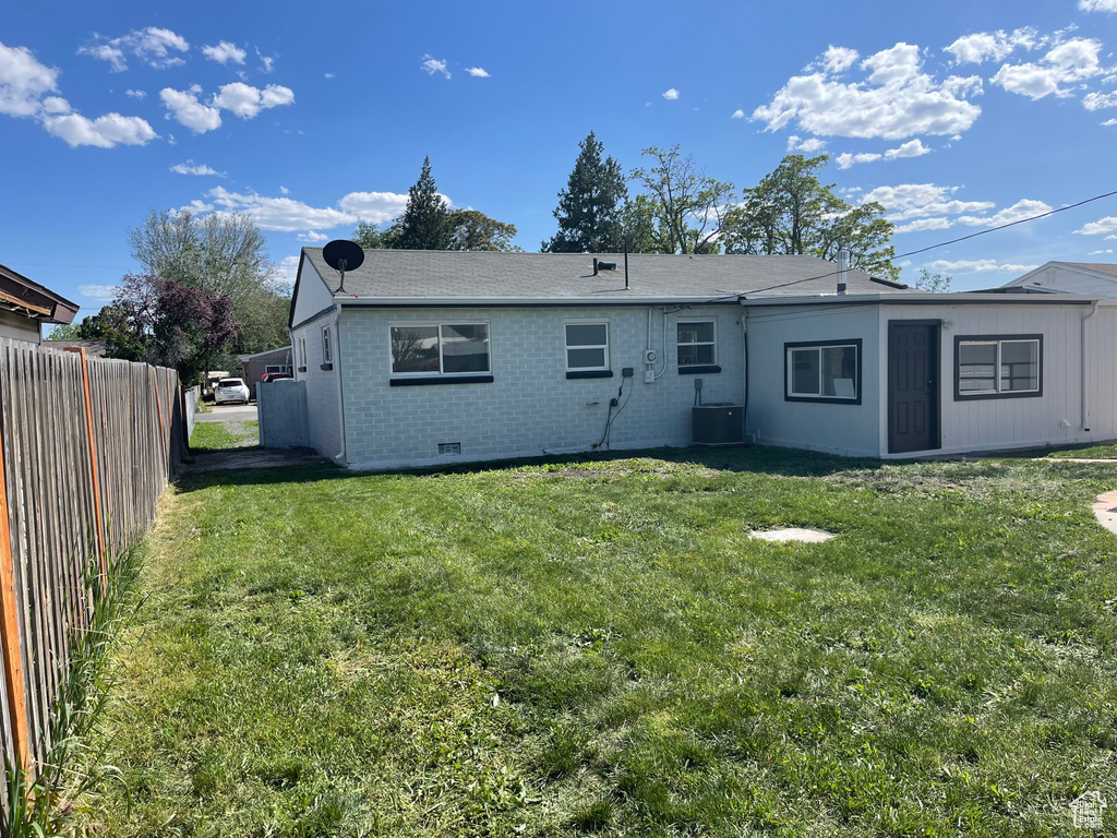 Back of house featuring brick siding, crawl space, and central AC