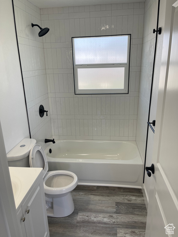 Full bath featuring wood finished floors, vanity, toilet, and shower / bath combination