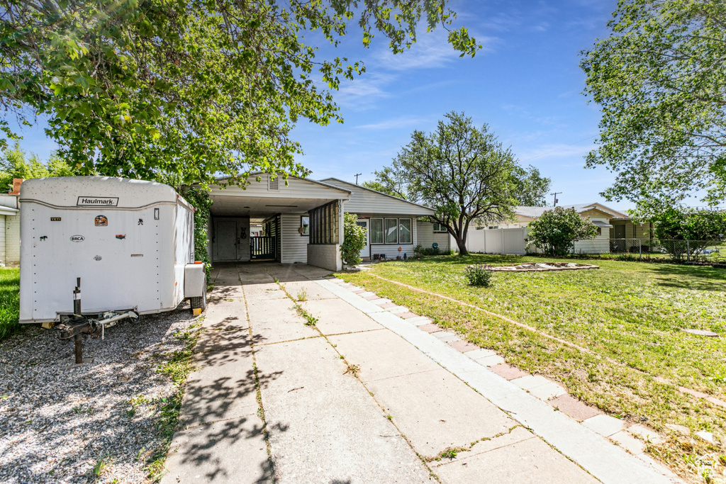 View of front of house featuring driveway and an attached carport