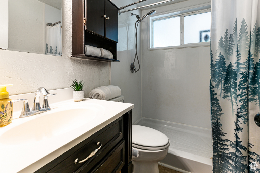 Full bathroom with a shower with shower curtain, toilet, and vanity