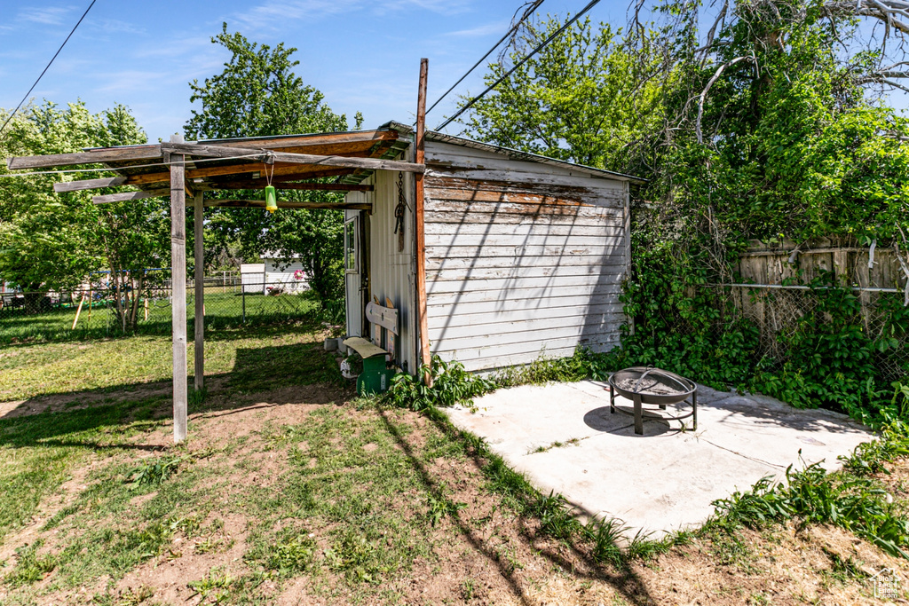 View of outbuilding featuring an outdoor fire pit and an outbuilding