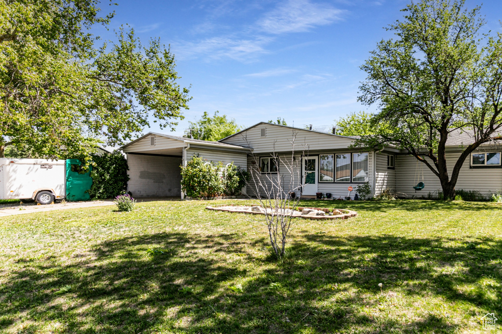 Ranch-style house featuring a front lawn, a sunroom, and a carport