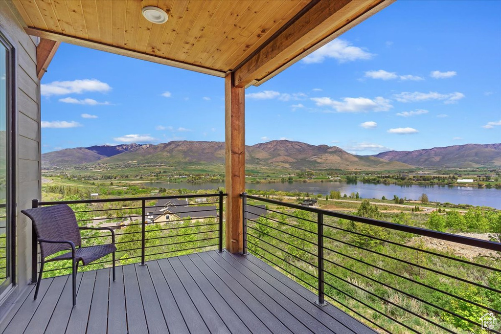 Wooden terrace featuring a water and mountain view