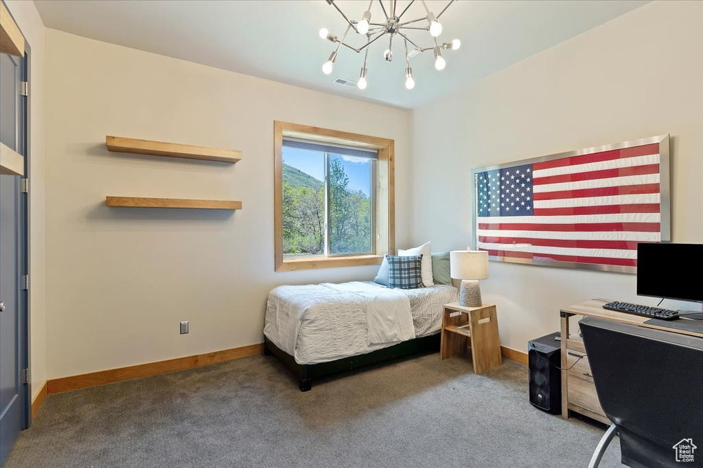 Bedroom featuring carpet, a chandelier, baseboards, and an office area