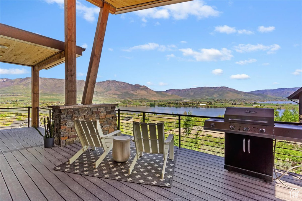 Wooden deck featuring a water and mountain view