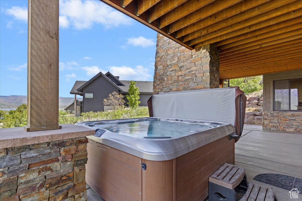 View of patio featuring a hot tub and a mountain view