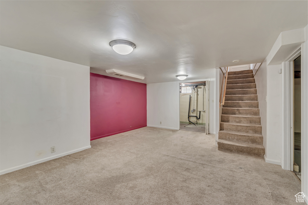 Finished basement featuring carpet flooring, stairway, and baseboards
