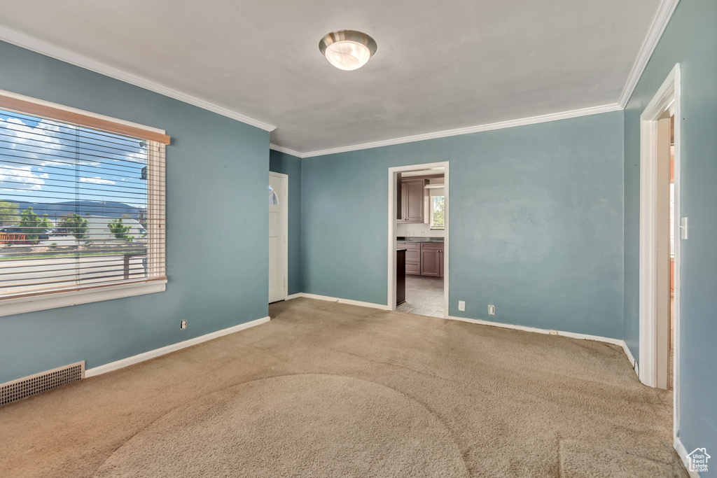 Unfurnished bedroom featuring crown molding, carpet floors, baseboards, and ensuite bathroom