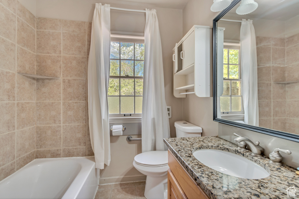 Full bathroom featuring tile patterned floors, toilet, vanity, and shower / bath combo