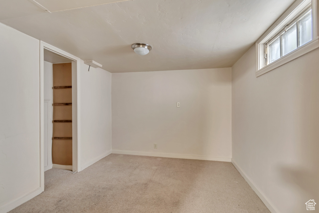 Basement with light carpet and baseboards
