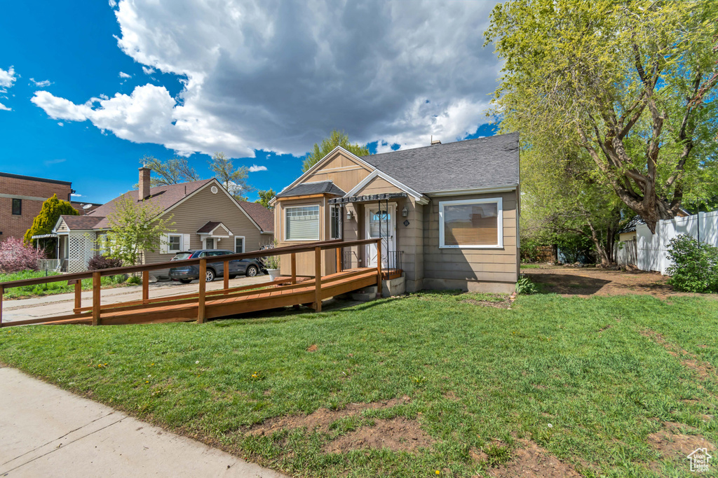 View of front of house featuring a deck and a shingled roof
