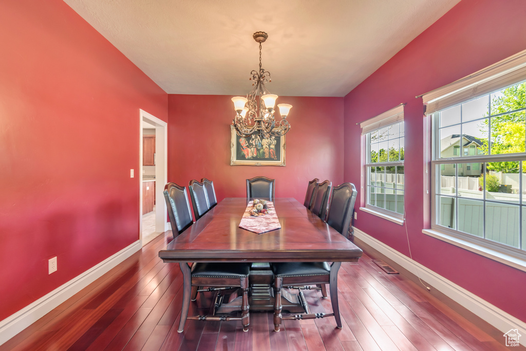 Dining space with a chandelier, hardwood / wood-style floors, and baseboards