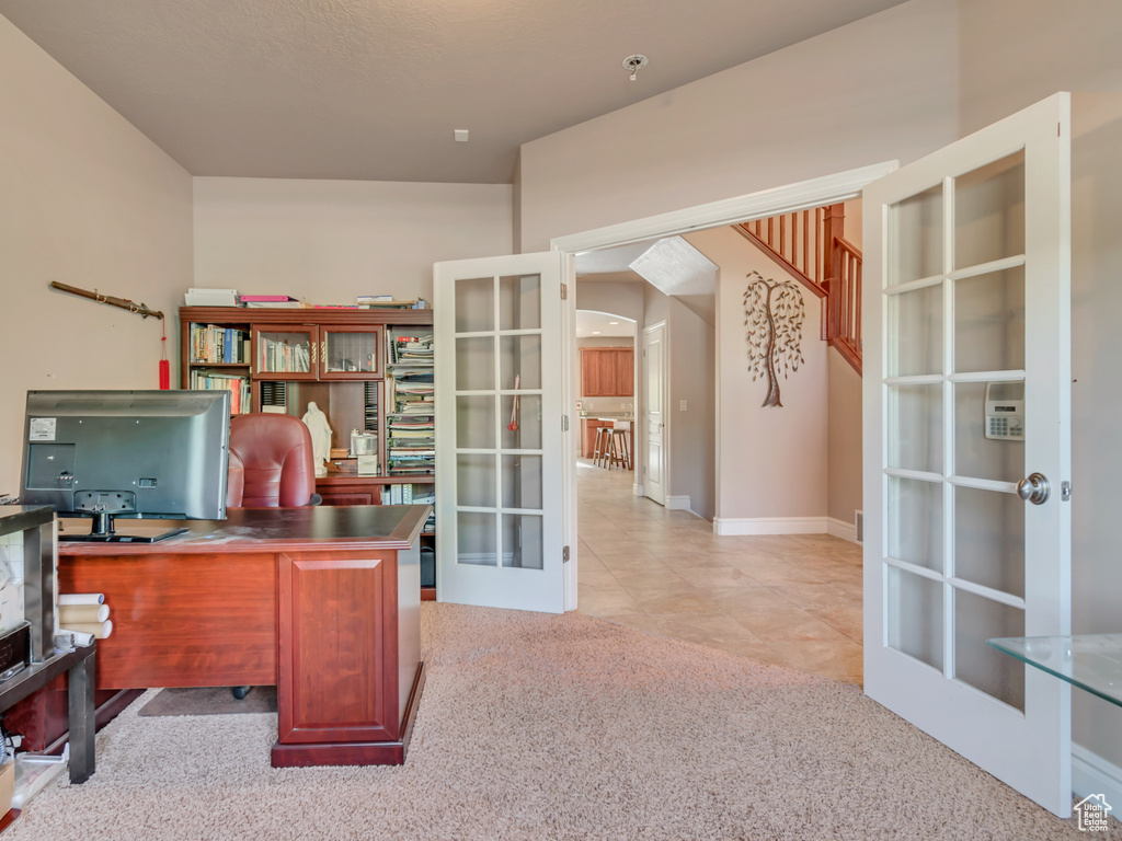 Home office with french doors, carpet floors, and baseboards