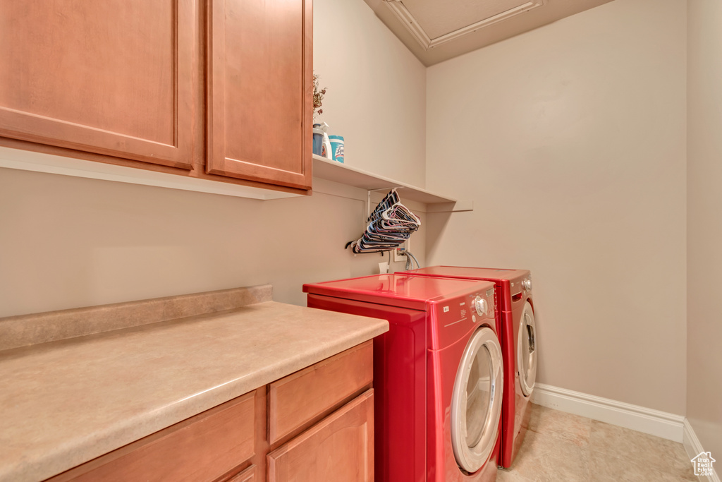Laundry room featuring independent washer and dryer, cabinet space, and baseboards