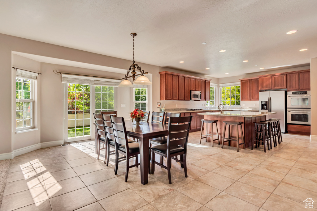 Dining space featuring light tile patterned flooring, healthy amount of natural light, recessed lighting, and baseboards