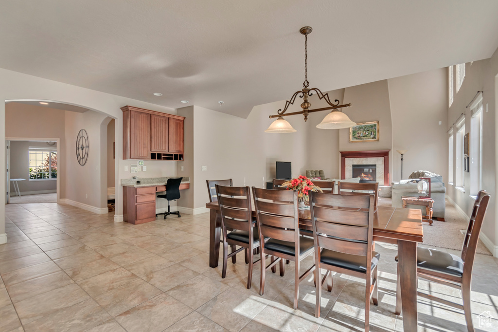 Dining room with arched walkways, baseboards, an office area, a fireplace, and recessed lighting