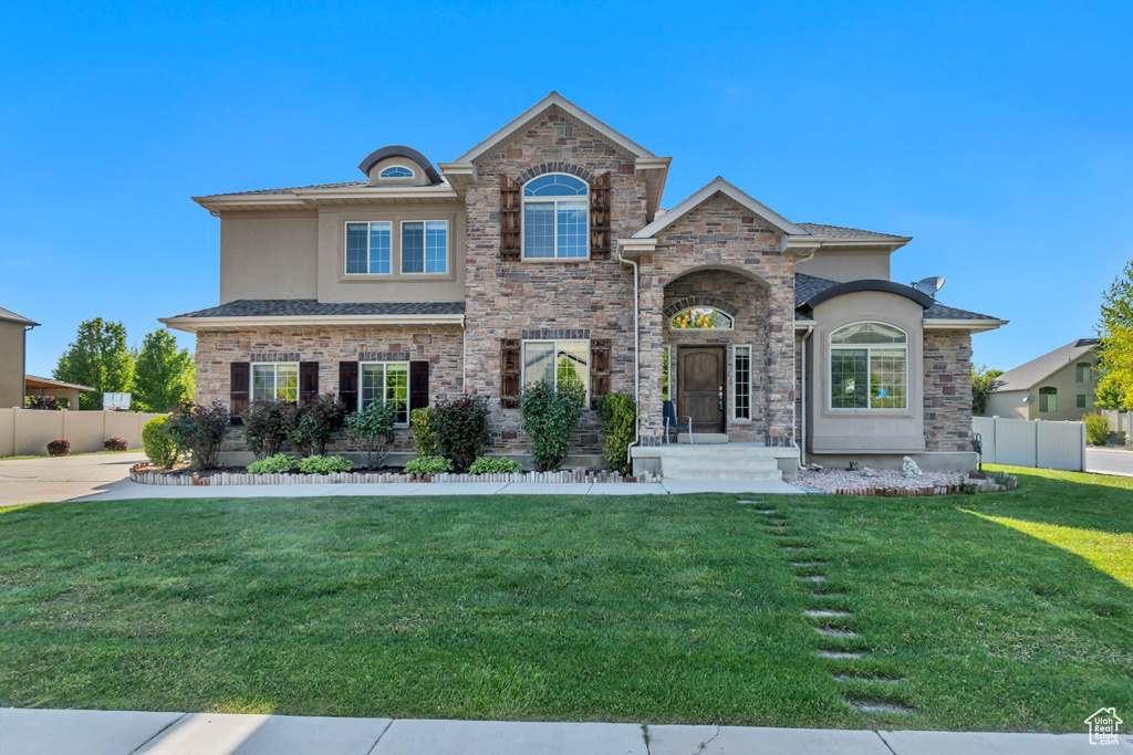 View of front of house with stucco siding and stone siding