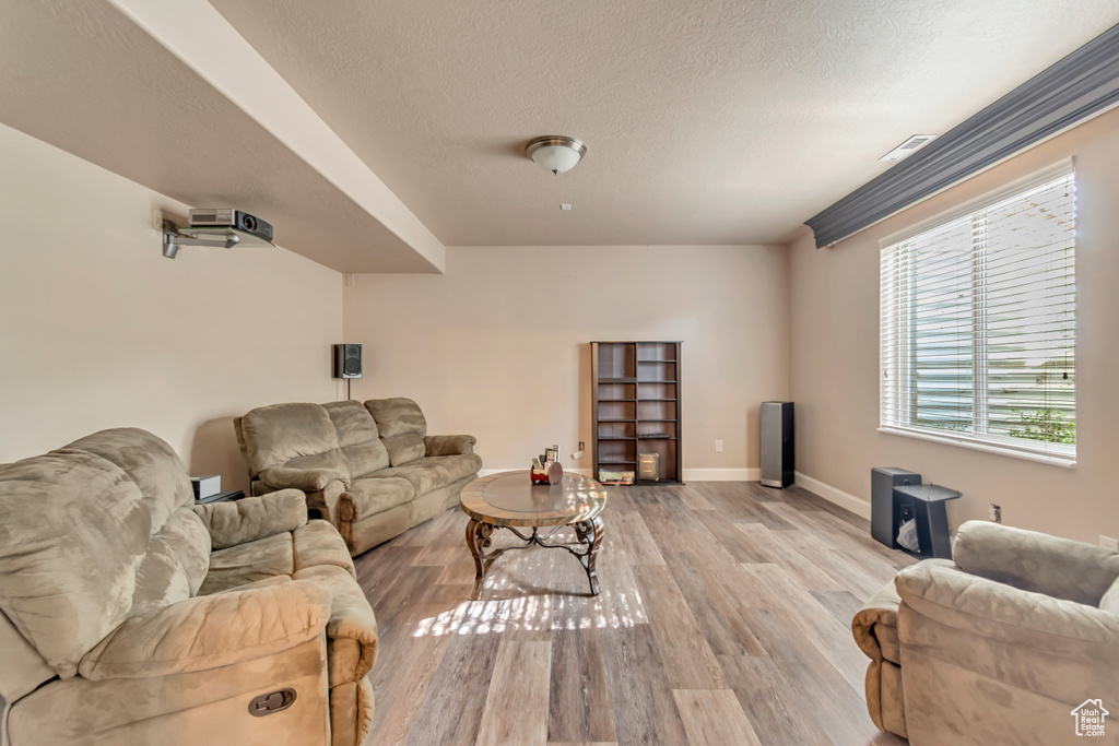 Living area featuring wood finished floors, baseboards, and a textured ceiling