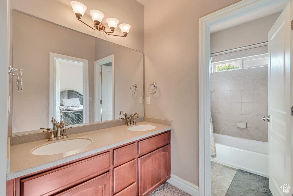 Bathroom with double vanity, shower / tub combo with curtain, and tile patterned flooring