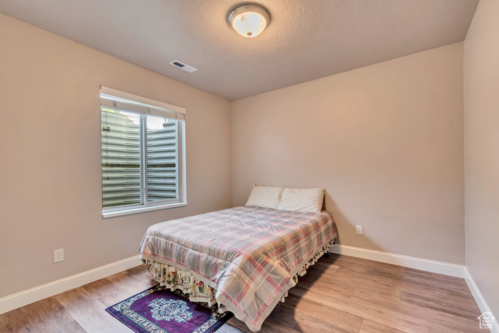 Bedroom with wood finished floors and baseboards
