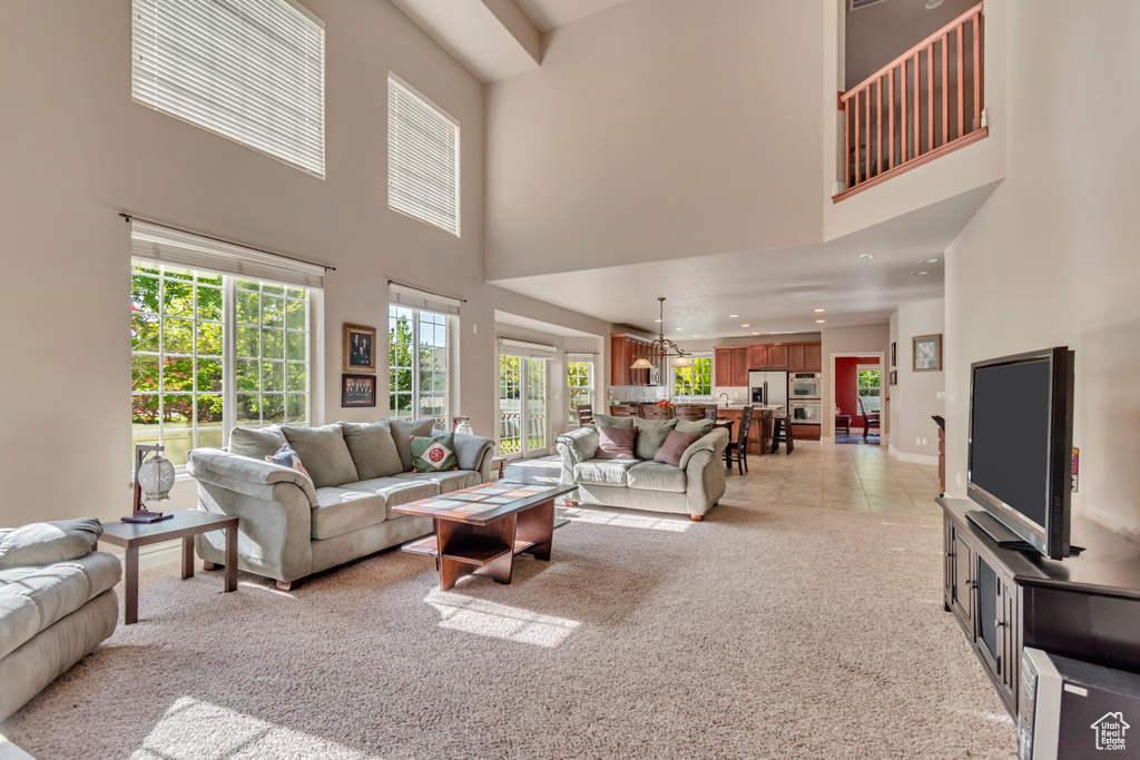 Living room with a towering ceiling, light carpet, and recessed lighting