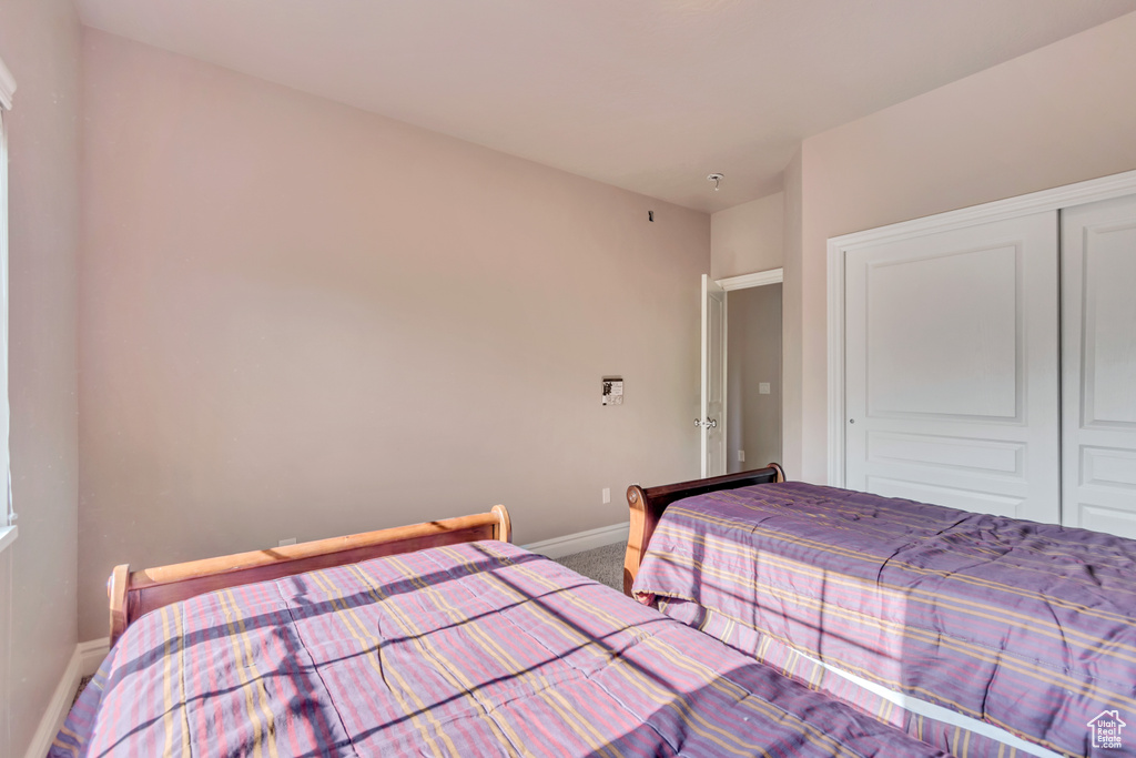 Carpeted bedroom featuring baseboards and a closet