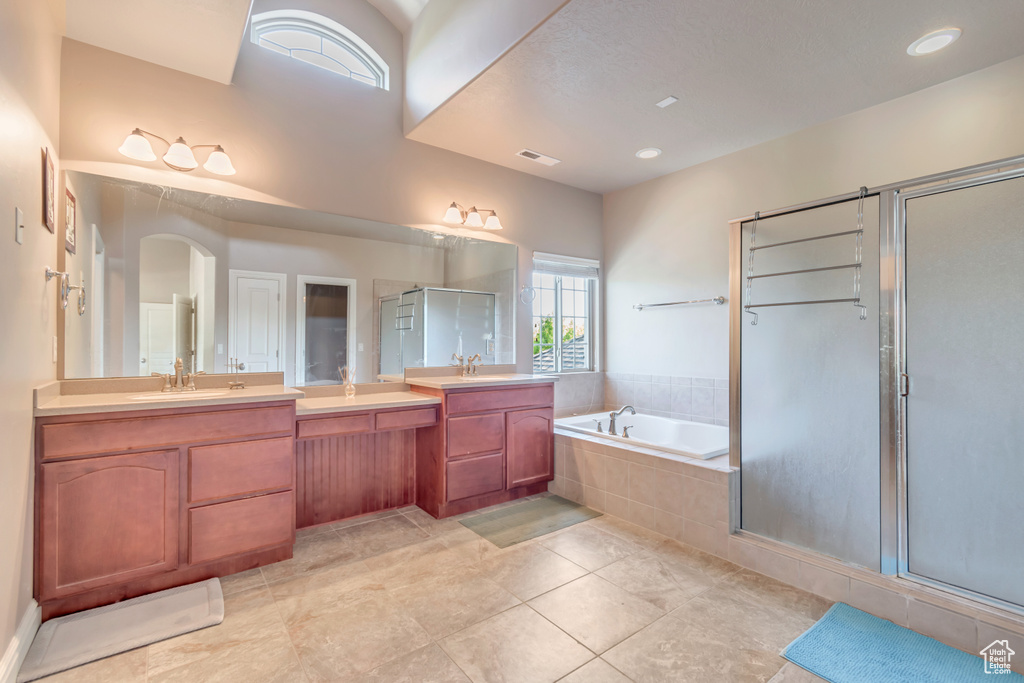 Full bathroom with a shower stall, a garden tub, vanity, and tile patterned floors