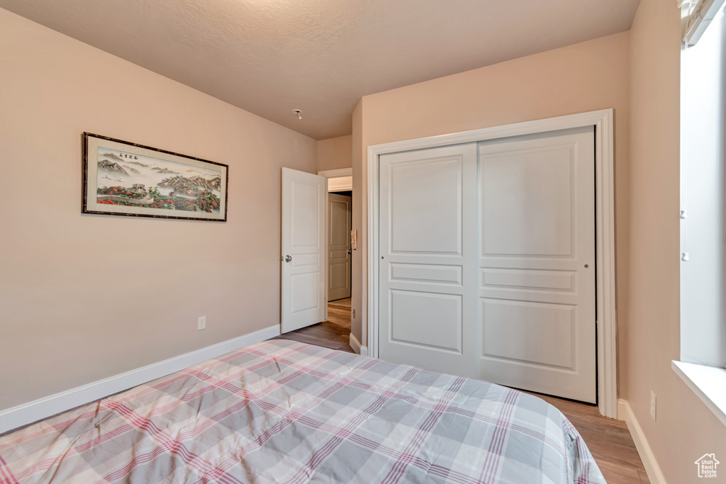 Unfurnished bedroom with baseboards, light wood-style floors, and a closet