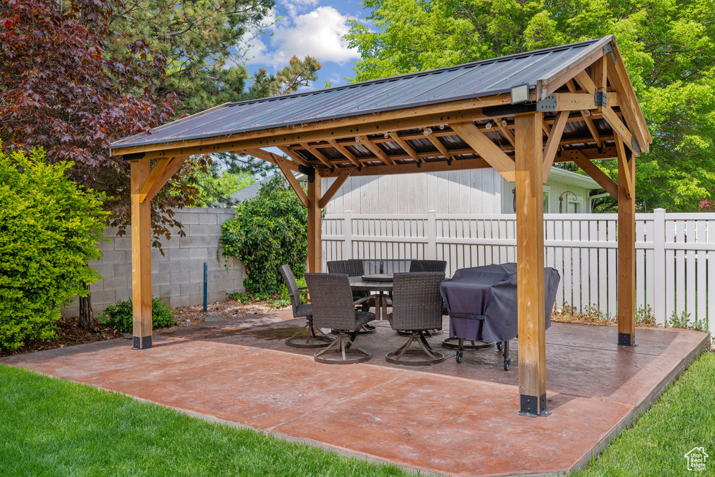 View of patio / terrace with a fenced backyard, outdoor dining space, a gazebo, and a grill