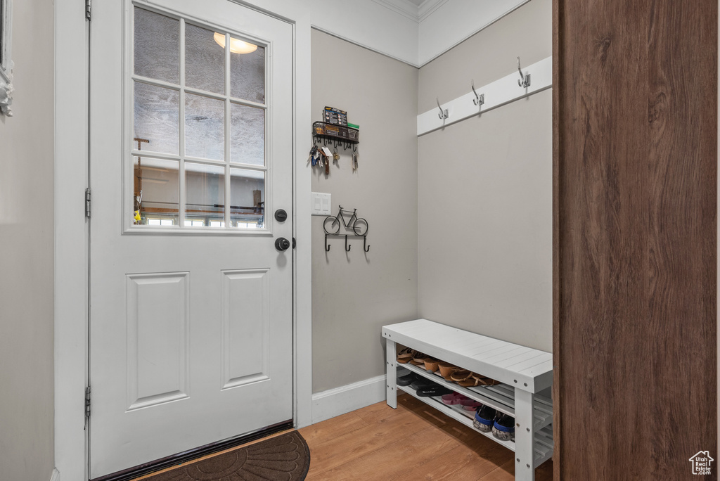 Mudroom featuring light wood-style flooring, baseboards, and ornamental molding