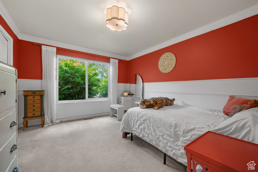 Bedroom with ornamental molding and carpet