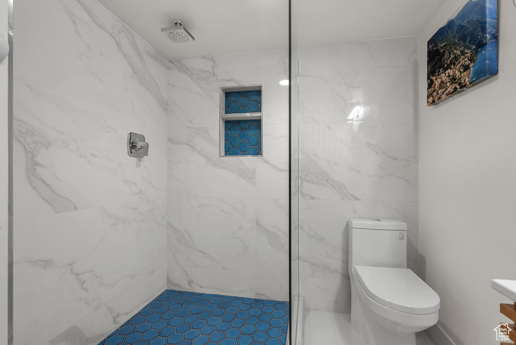 Full bathroom featuring a marble finish shower and toilet