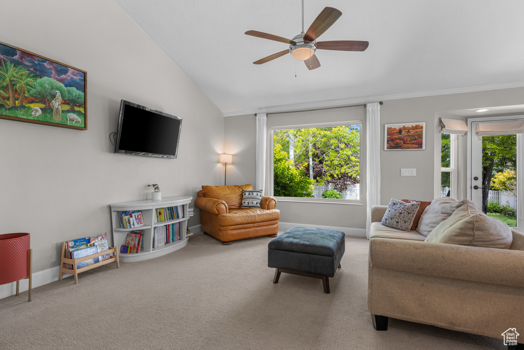 Carpeted living room featuring vaulted ceiling, a ceiling fan, and baseboards