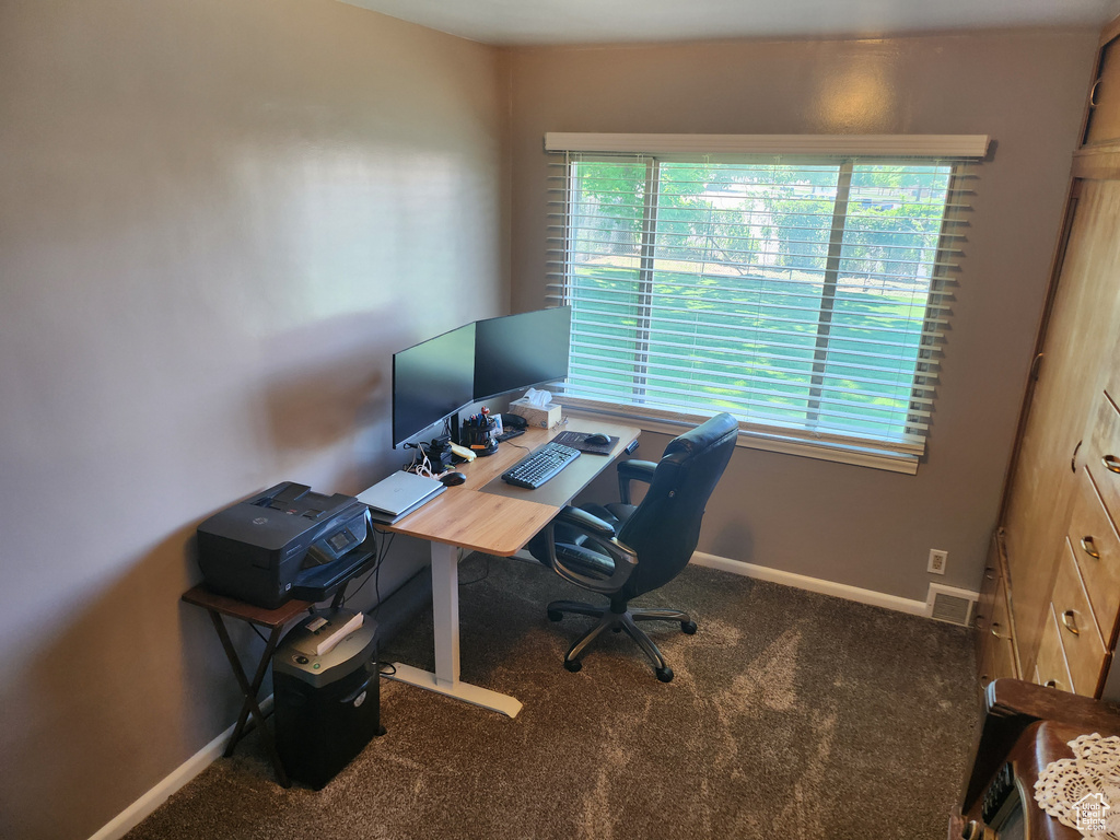 Carpeted home office featuring baseboards