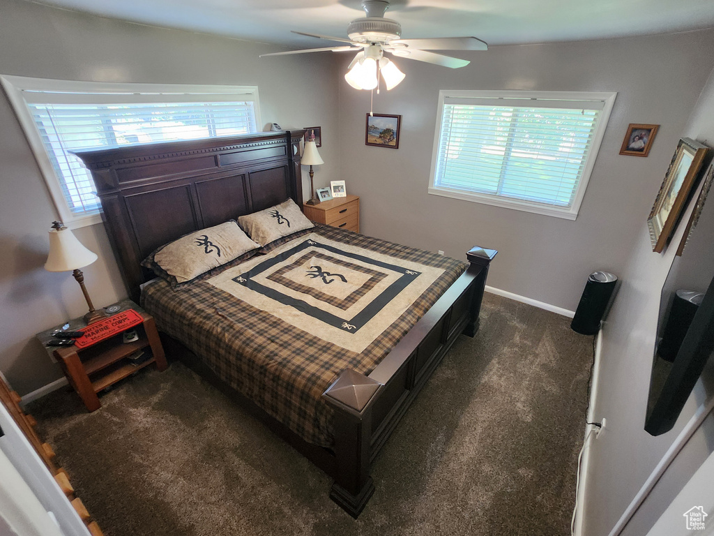 Bedroom featuring dark carpet, baseboards, and a ceiling fan