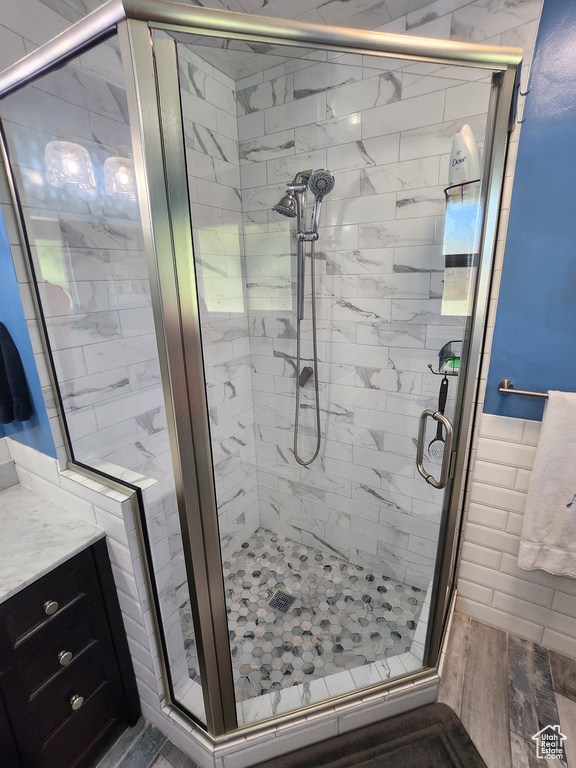 Bathroom with a shower stall and wood finished floors