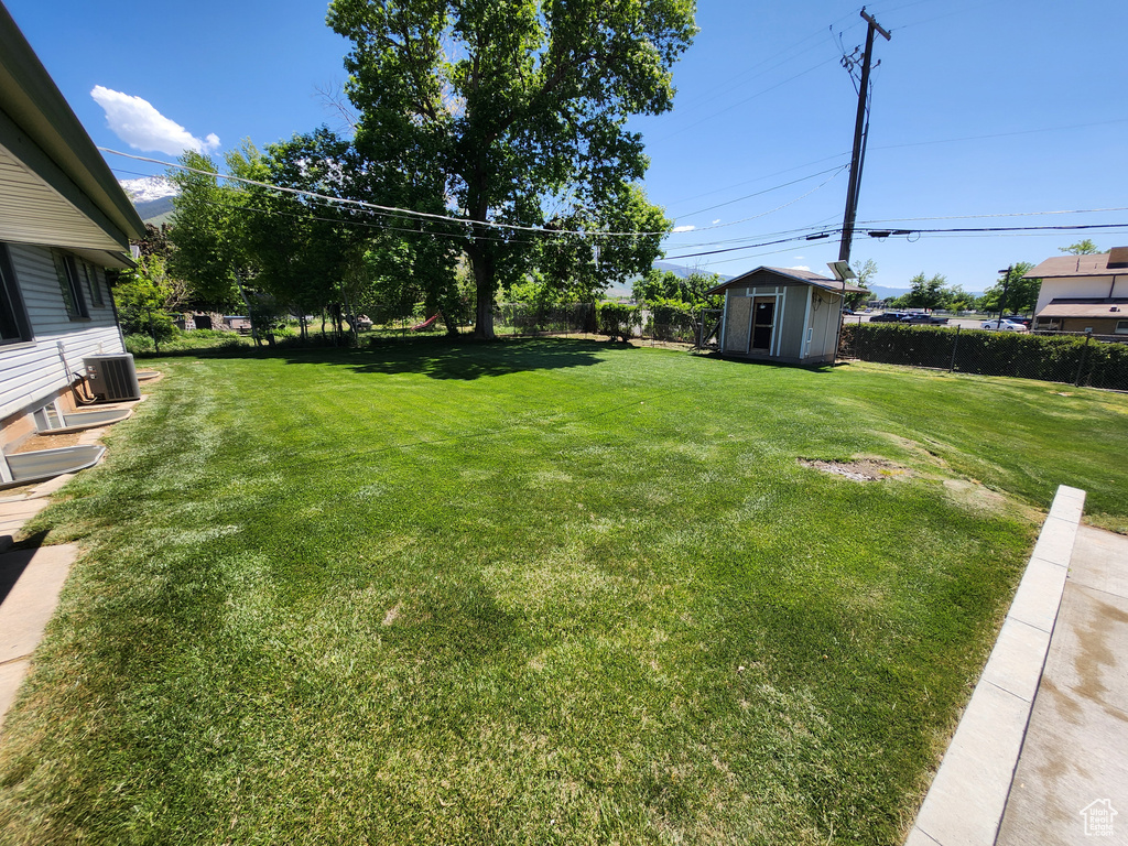 View of yard with a storage shed, an outdoor structure, and cooling unit