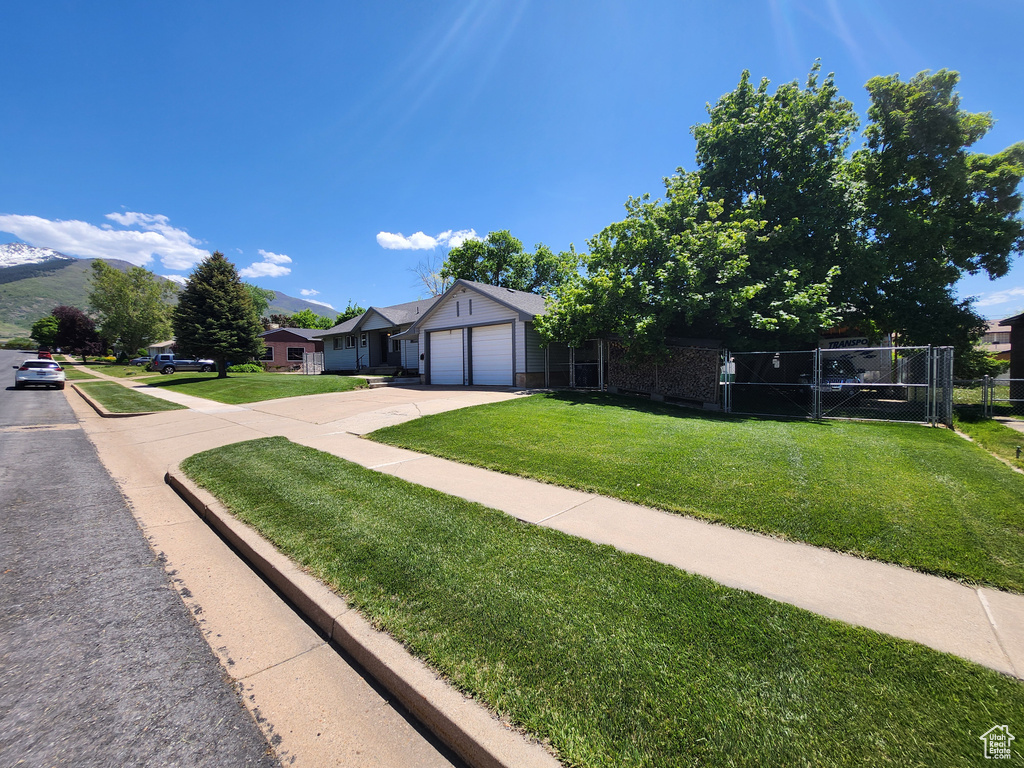 Single story home with concrete driveway and an attached garage