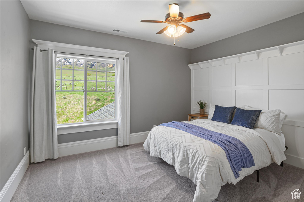 Carpeted bedroom with baseboards and a ceiling fan