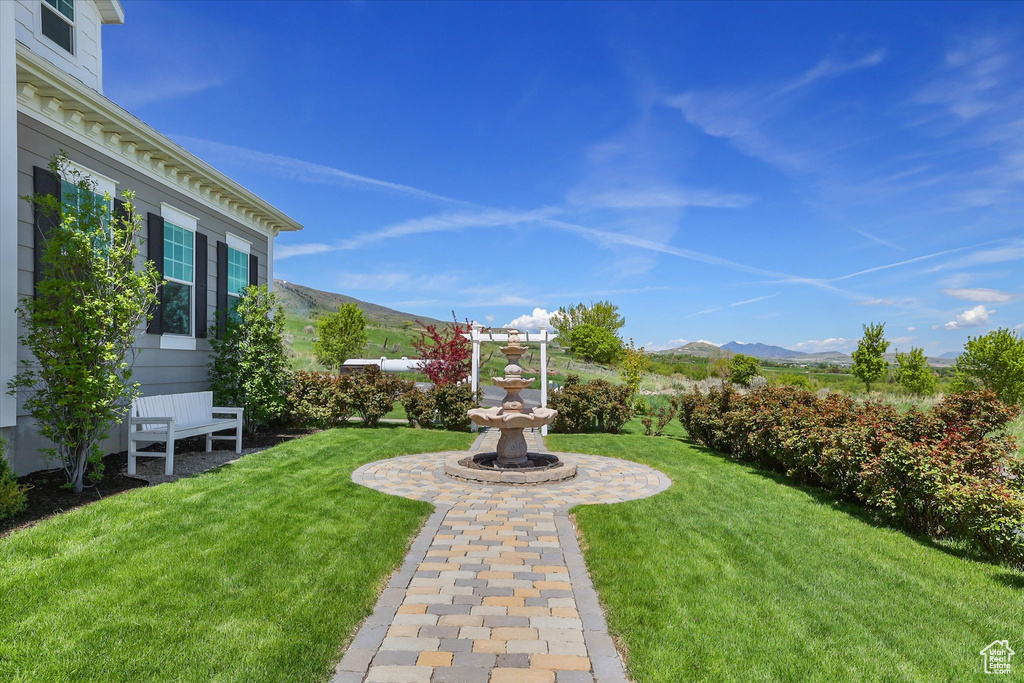 View of green lawn featuring a mountain view
