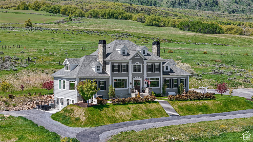 View of front facade with a chimney, a rural view, and french doors