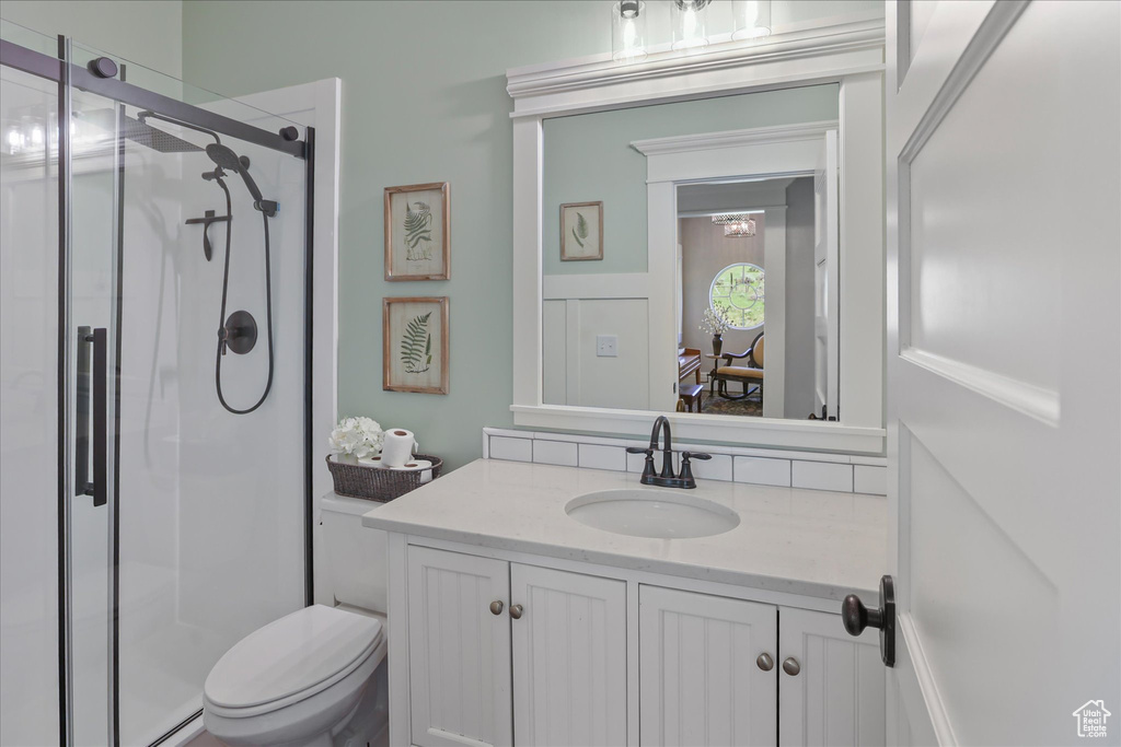 Full bath featuring a stall shower, vanity, toilet, and a baseboard heating unit