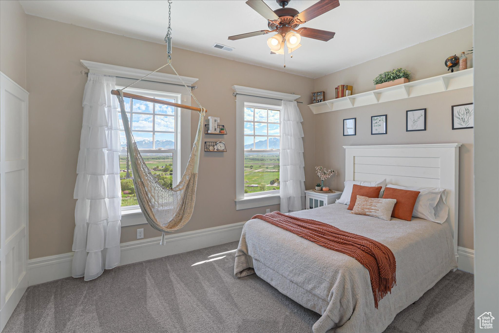 Carpeted bedroom featuring baseboards and a ceiling fan