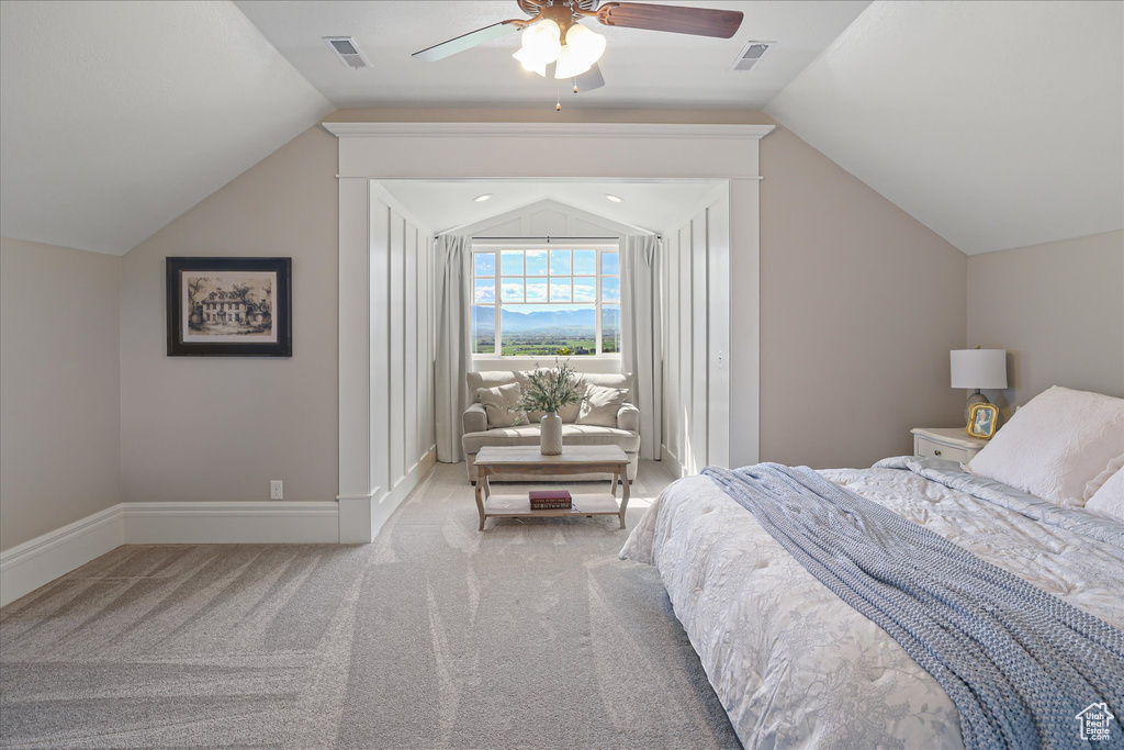Carpeted bedroom with vaulted ceiling, baseboards, and ceiling fan