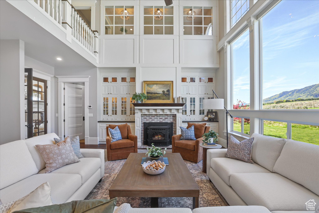 Living room featuring healthy amount of natural light, a towering ceiling, baseboards, wood finished floors, and recessed lighting